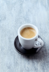 Cup of coffee on bright wooden background. Copy space.