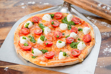 Pizza tomato and cheese mozzarella on  the wood table oven peel paddle