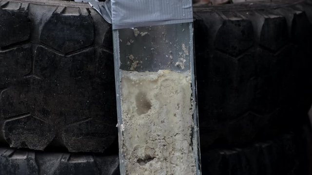 A plumber is testing a sewer cleaner. Demonstration of the inefficiency of drain cleaners on the example of a sewer pipe in the context. Clogged pipe.