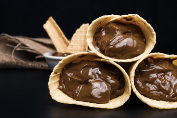 Wafer rolls with condensed milk on a white plate.
