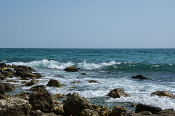 Fototapeta na wymiar Beautiful wild beach landscape, sunny day, water waves hitting the cliffs, nature summertime scene