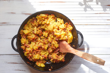 Baked potatoes with minced meat, onions and carrots baked in a pan.