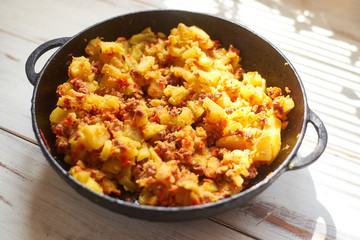 Baked potatoes with minced meat, onions and carrots baked in a pan.