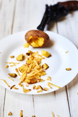 Despair, tired of cooking in the kitchen concept. A shot from a pistol at a potato.