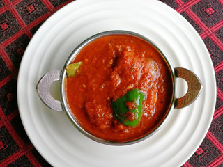 Chicken Tikka masala in kadai on a white plate. Delicious spicy Indian dish. Top view, flat lay