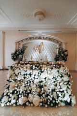 Decor of white roses at the wedding. Bridal table decorated with flowers.