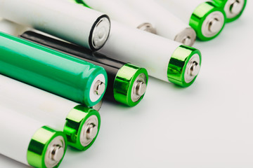 many new and used alkaline the positive ends of battery cells. type AA on a light background.