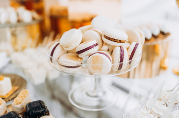 Macarons with chocolate. Sweet table with macaroons. Candy bar or dessert table with macarons and other sweets.