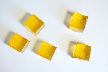 Yellow jelly cubes on a white background