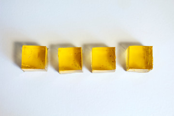 Yellow jelly cubes on a white background