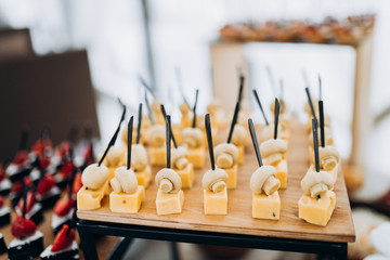 Chunks of cheese on the buffet table. Cheese slicing. Festive table with dishes. Delicious dishes on the table in the restaurant. Cheese. Food.