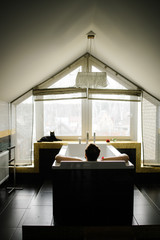 interior of a bath with a silhouette of a man with a window on which a cat is sitting