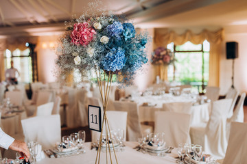 Beautiful flowers on table in wedding day. The white round banquet table in the restaurant is decorated with fresh flowers. 