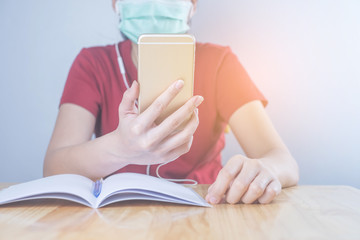 Asian woman wear hygiene protective mask to protect COVID 19, making facetime video call with smartphone at home, social distancing, working from home, work remotely concept.