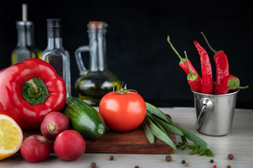 Vegan concept, vegetable salad in a transparent glass plate, in a blurred background olive oil in a bottle, shallow depth of field, selective focus.