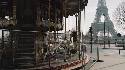 Paris, France / 04 13 2020 : Closed carousel and deserted Eiffel tower during coronavirus / Covid-19 lockdown in Paris 4K
