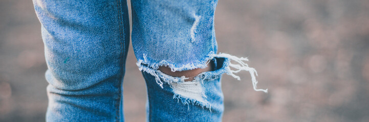 girls legs in torn jeans on their knees