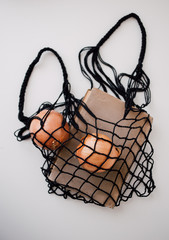 Fototapeta na wymiar string bag with book and onions