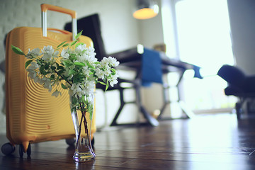 spring trip, a bouquet of flowers of an apple tree and a yellow suitcase
