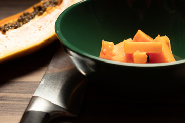 Tijela com pedaços de mamão e fatia de mamão