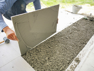 The man hand while using spacer for installing tiles.,Focus on the left hand side. construction...