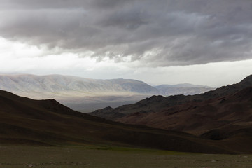 Dark mountain under a stormy evening dramatic cloudy sky. Altai, Mongolia