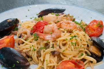 Spaghetti pasta with shrimp, mussels, tomatoes and cheese. Tasty, traditional food from Italy
