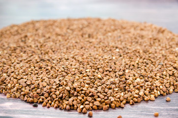 buckwheat on a wooden background. Close-up. Pile of buckwheat on the table.