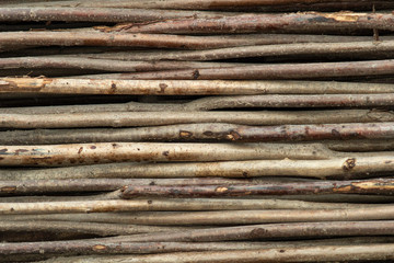 Fence of horizontal thin trunks of young trees. Natural background