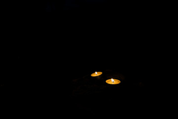 religious spiritual silence atmosphere of two candle in the dark fire flame in black background environment space for your copy or text