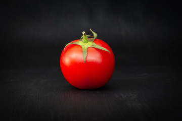 Red cherry tomato isolated on black