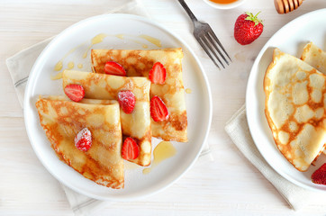 Homemade thin pancakes with strawberry slices