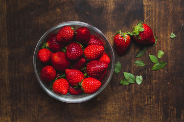 Strawberry bowls on a rustic wooden table
