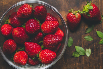 Strawberry bowls on a rustic wooden table