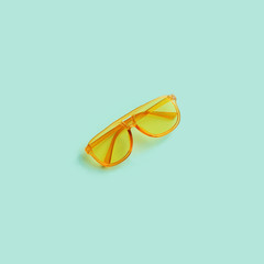 Yellow transparent frame trendy sunglasses on abstract mint background isolated. Copy space. Summer...
