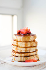 Vertical photo, pancakes with strawberries and caramel sauce