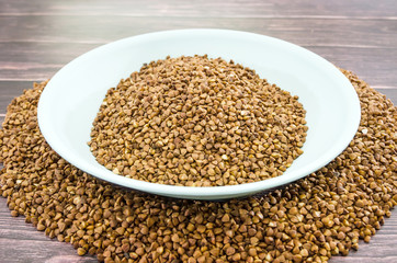 buckwheat in a plate on a wooden background.