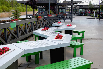 Stone tables with chess boards for playing chess outdoors in the Park. Leisure and entertainment for visitors to the Park.