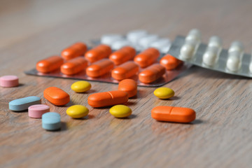 Assorted colored tablets and tablet packaging close-up on the table. Concept of protection and...
