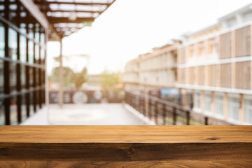 Empty wood table platform with bokeh light of city background for product presentation display montage.