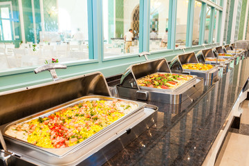 A row of food containers in hotel restaurant