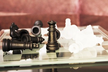 Abstract chess broad with Queen chess standing  the rest chess  lay down. photo 