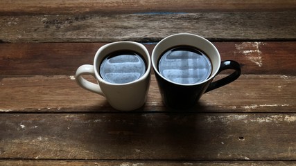 Espresso,black coffee in mug on empty old wood table top,dimly light,with lens flare,free space for text design.2 Coffee cup for couple of love,friend etc.Concept of Relaxation in Coffee time.