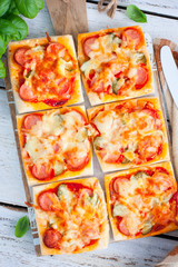 Puff pastry mini pizza with sausages and cucumbers, top view