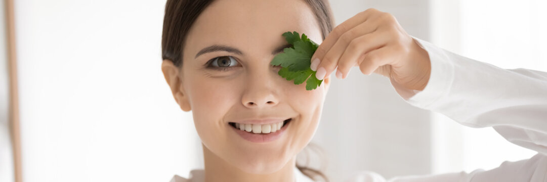 Panoramic horizontal banner or happy millennial Caucasian girl hold parsley recommend chewing for fresh breath, smiling young woman freshen whiten teeth with garnish, natural product for oral care