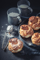 Yummy and sweet cream puffs on old metal plate