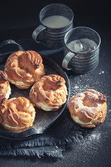 Small and fresh cream puffs on rustic dark table