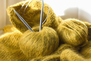 threads and knitting needles. Knitting blankets. Knitted sweater. Needlework as a hobby and business