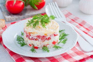 Homemade salad with crab sticks, tomatoes, cheese on a white dish, horizontal
