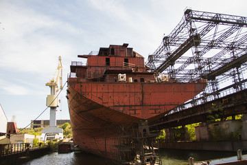 Rusty, abandoned ship under construction, unfinished ship at the factory.